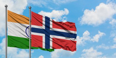 Hindistan ve Norveç bayrağı birlikte beyaz bulutlu mavi gökyüzüne karşı rüzgarsal sallayarak. Diplomasi kavramı, uluslararası ilişkiler.