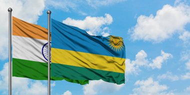 Hindistan ve Ruanda bayrağı birlikte beyaz bulutlu mavi gökyüzüne karşı rüzgarda sallayarak. Diplomasi kavramı, uluslararası ilişkiler.