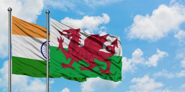 Hindistan ve Galler bayrağı birlikte beyaz bulutlu mavi gökyüzüne karşı rüzgarda sallayarak. Diplomasi kavramı, uluslararası ilişkiler.