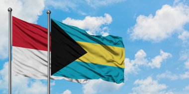 Irak ve Bahamalar bayrağı birlikte beyaz bulutlu mavi gökyüzüne karşı rüzgarda sallayarak. Diplomasi kavramı, uluslararası ilişkiler.