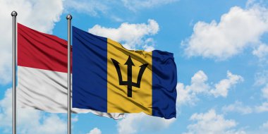 Irak ve Barbados bayrağı birlikte beyaz bulutlu mavi gökyüzüne karşı rüzgarda sallayarak. Diplomasi kavramı, uluslararası ilişkiler.