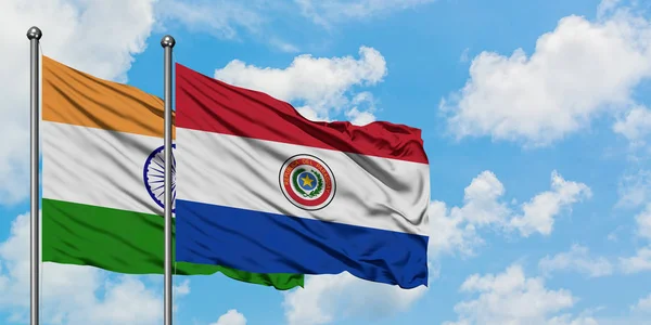 Bandera de la India y Paraguay ondeando en el viento contra el cielo azul nublado blanco juntos. Concepto diplomático, relaciones internacionales . — Foto de Stock