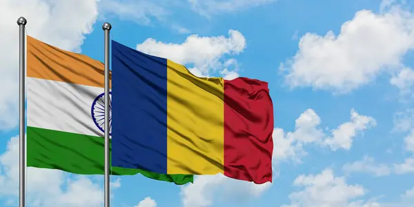 Bandera de la India y Rumania ondeando en el viento contra el cielo azul nublado blanco juntos. Concepto diplomático, relaciones internacionales . — Foto de Stock