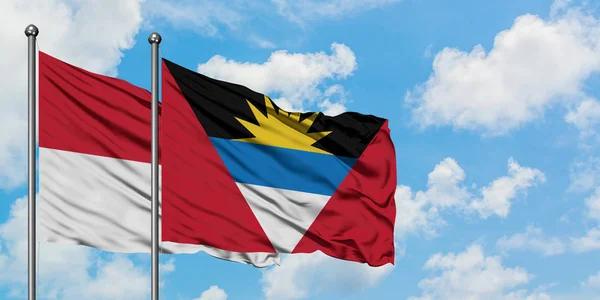 Bandera de Irak y Antigua y Barbuda ondeando en el viento contra el cielo azul nublado blanco juntos. Concepto diplomático, relaciones internacionales . — Foto de Stock