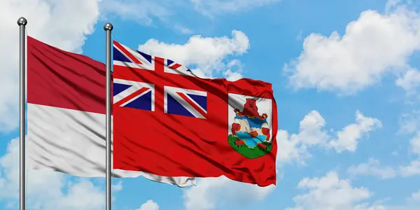Iraq e bandiera delle Bermuda sventolano insieme contro il bianco cielo azzurro nuvoloso. Concetto di diplomazia, relazioni internazionali . — Foto Stock