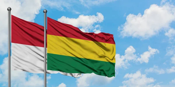 Bandera de Irak y Bolivia ondeando en el viento contra el cielo azul nublado blanco juntos. Concepto diplomático, relaciones internacionales . — Foto de Stock