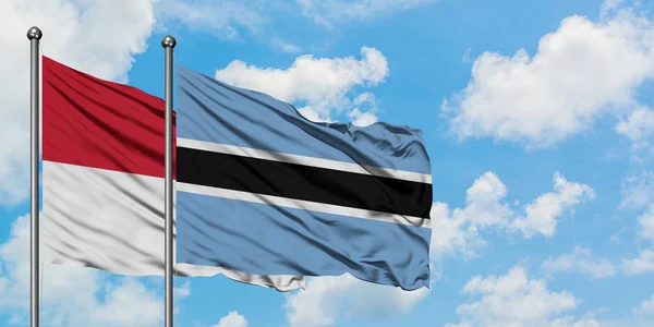 Iraq e Botswana sventolano insieme la bandiera contro il bianco cielo azzurro nuvoloso. Concetto di diplomazia, relazioni internazionali . — Foto Stock