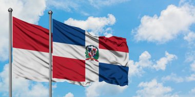 Irak ve Dominik Cumhuriyeti bayrağı birlikte beyaz bulutlu mavi gökyüzüne karşı rüzgarda sallayarak. Diplomasi kavramı, uluslararası ilişkiler.