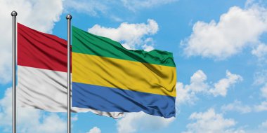 Irak ve Gabon bayrağı birlikte beyaz bulutlu mavi gökyüzüne karşı rüzgarda sallayarak. Diplomasi kavramı, uluslararası ilişkiler.