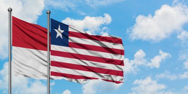 Irak ve Liberya bayrağı birlikte beyaz bulutlu mavi gökyüzüne karşı rüzgarda sallayarak. Diplomasi kavramı, uluslararası ilişkiler.