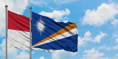 Irak ve Marshall Adaları bayrağı birlikte beyaz bulutlu mavi gökyüzüne karşı rüzgarda sallayarak. Diplomasi kavramı, uluslararası ilişkiler.