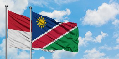 Irak ve Namibya bayrağı birlikte beyaz bulutlu mavi gökyüzüne karşı rüzgarda sallayarak. Diplomasi kavramı, uluslararası ilişkiler.