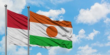 Irak ve Nijer bayrağı birlikte beyaz bulutlu mavi gökyüzüne karşı rüzgarda sallayarak. Diplomasi kavramı, uluslararası ilişkiler.