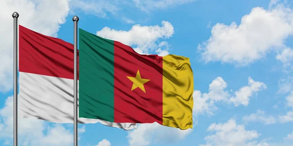 Bandera de Irak y Camerún ondeando en el viento contra el cielo azul nublado blanco juntos. Concepto diplomático, relaciones internacionales . — Foto de Stock