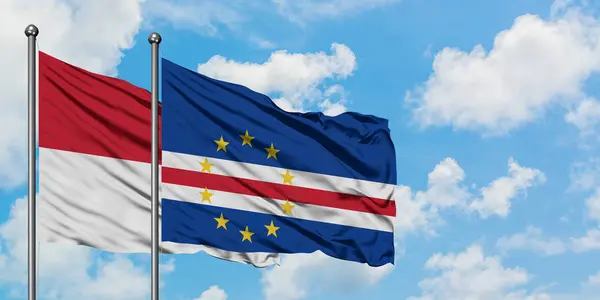 Bandera de Irak y Cabo Verde ondeando en el viento contra el cielo azul nublado blanco juntos. Concepto diplomático, relaciones internacionales . — Foto de Stock