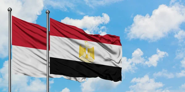 Bandera de Irak y Egipto ondeando en el viento contra el cielo azul nublado blanco juntos. Concepto diplomático, relaciones internacionales . — Foto de Stock