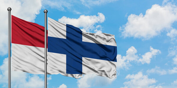 Iraq and Finland flag waving in the wind against white cloudy blue sky together. Diplomacy concept, international relations.