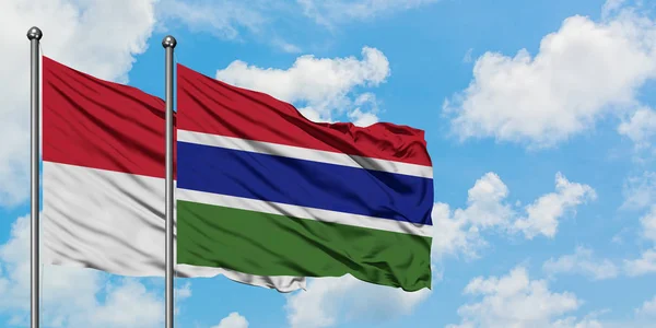 Irak- und Gambia-Flagge wehen gemeinsam im Wind gegen den wolkenverhangenen blauen Himmel. Diplomatie-Konzept, internationale Beziehungen. — Stockfoto