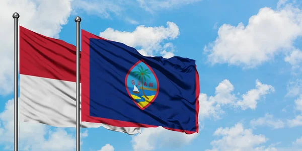 Irak és Guam zászló integetett a szél ellen, fehér felhős kék ég együtt. Diplomáciai koncepció, nemzetközi kapcsolatok. — Stock Fotó