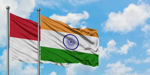 Bandera de Irak e India ondeando en el viento contra el cielo azul nublado blanco juntos. Concepto diplomático, relaciones internacionales . — Foto de Stock