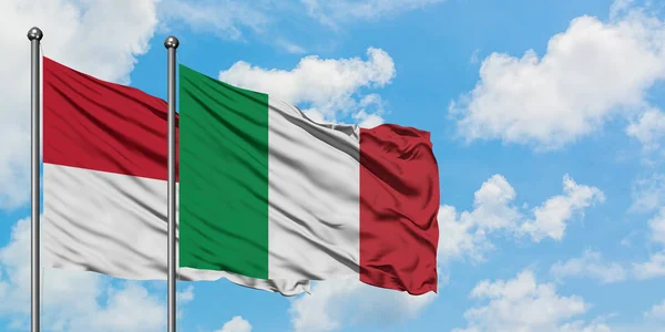 Bandera de Irak e Italia ondeando en el viento contra el cielo azul nublado blanco juntos. Concepto diplomático, relaciones internacionales . — Foto de Stock