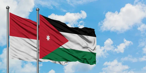 Bandera de Irak y Jordania ondeando en el viento contra el cielo azul nublado blanco juntos. Concepto diplomático, relaciones internacionales . — Foto de Stock