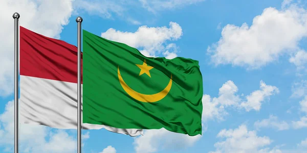 Bandera de Irak y Mauritania ondeando en el viento contra el cielo azul nublado blanco juntos. Concepto diplomático, relaciones internacionales . — Foto de Stock