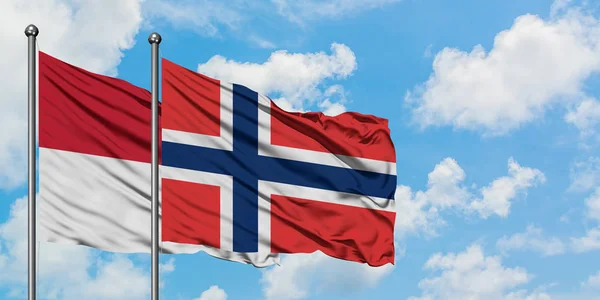 Bandera de Irak y Noruega ondeando en el viento contra el cielo azul nublado blanco juntos. Concepto diplomático, relaciones internacionales . — Foto de Stock