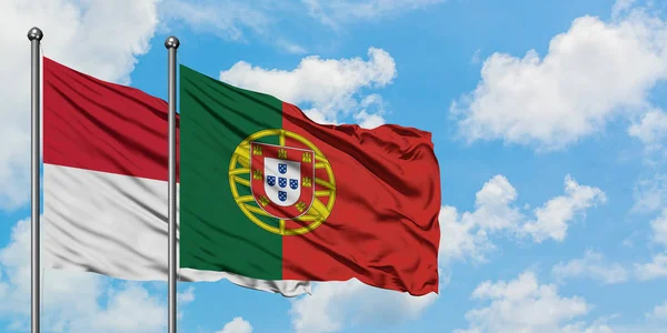 Iraq and Portugal flag waving in the wind against white cloudy blue sky together. Diplomacy concept, international relations. — Stock Photo, Image