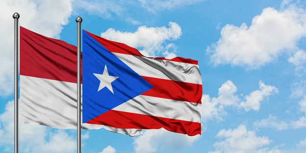 Irak ve Porto Riko bayrağı birlikte beyaz bulutlu mavi gökyüzüne karşı rüzgarda sallayarak. Diplomasi kavramı, uluslararası ilişkiler. — Stok fotoğraf