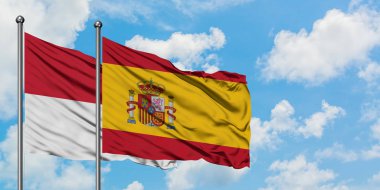 Irak ve İspanya bayrağı birlikte beyaz bulutlu mavi gökyüzüne karşı rüzgarsal sallayarak. Diplomasi kavramı, uluslararası ilişkiler.