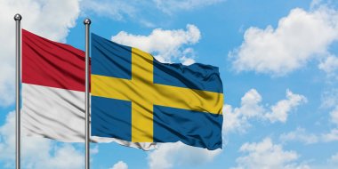 Irak ve İsveç bayrağı birlikte beyaz bulutlu mavi gökyüzüne karşı rüzgarsal sallayarak. Diplomasi kavramı, uluslararası ilişkiler.