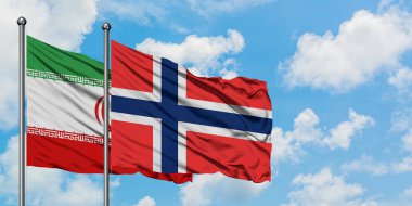 İran ve Bouvet Adaları bayrağı birlikte beyaz bulutlu mavi gökyüzüne karşı rüzgarsal sallayarak. Diplomasi kavramı, uluslararası ilişkiler.