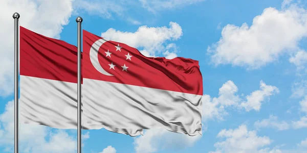Η σημαία του Ιράκ και της Σιγκαπούρης κουνώντας τον άνεμο εναντίον του λευκού νεφελώδη μπλε ουρανού μαζί. Φιλοσοφία της διπλωματίας, διεθνείς σχέσεις. — Φωτογραφία Αρχείου