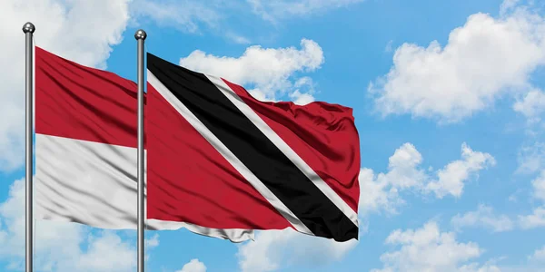 Irak en Trinidad en Tobago vlag zwaaien in de wind tegen witte bewolkte blauwe hemel samen. Diplomatie concept, internationale betrekkingen. — Stockfoto