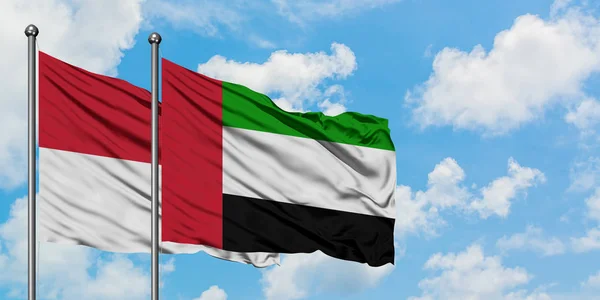 Bandera de Irak y Emiratos Árabes Unidos ondeando en el viento contra el cielo azul nublado blanco juntos. Concepto diplomático, relaciones internacionales . — Foto de Stock