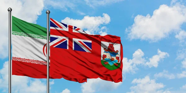 Bandera de Irán y Bermudas ondeando en el viento contra el cielo azul nublado blanco juntos. Concepto diplomático, relaciones internacionales . —  Fotos de Stock