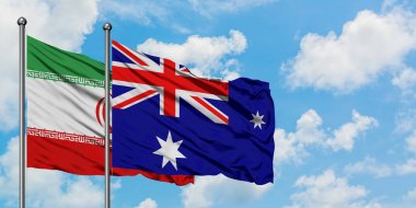 İran ve Heard Adası ve Mcdonald Adaları bayrağı birlikte beyaz bulutlu mavi gökyüzüne karşı rüzgarda sallayarak. Diplomasi kavramı, uluslararası ilişkiler.