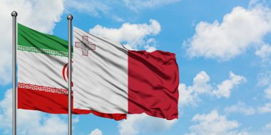 İran ve Malta bayrağı birlikte beyaz bulutlu mavi gökyüzüne karşı rüzgarda sallayarak. Diplomasi kavramı, uluslararası ilişkiler.