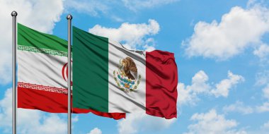 İran ve Meksika bayrağı birlikte beyaz bulutlu mavi gökyüzüne karşı rüzgarda sallayarak. Diplomasi kavramı, uluslararası ilişkiler.