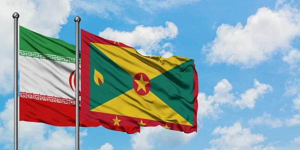 Bandera de Irán y Granada ondeando en el viento contra el cielo azul nublado blanco juntos. Concepto diplomático, relaciones internacionales . — Foto de Stock