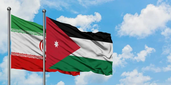 Iran ja Jordania lippu heiluttavat tuulessa valkoista pilvistä sinistä taivasta vasten yhdessä. Diplomatian käsite, kansainväliset suhteet . — kuvapankkivalokuva