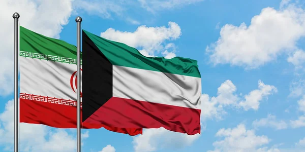 Bandera de Irán y Kuwait ondeando en el viento contra el cielo azul nublado blanco juntos. Concepto diplomático, relaciones internacionales . — Foto de Stock