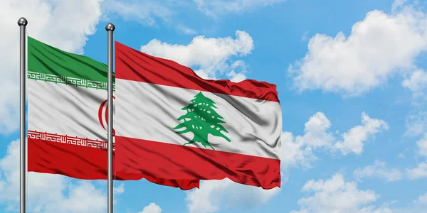Bandera de Irán y Líbano ondeando en el viento contra el cielo azul nublado blanco juntos. Concepto diplomático, relaciones internacionales . — Foto de Stock