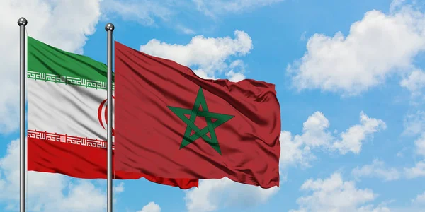 Bandera de Irán y Marruecos ondeando en el viento contra el cielo azul nublado blanco juntos. Concepto diplomático, relaciones internacionales . — Foto de Stock