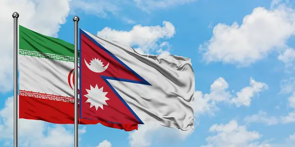 Bandera de Irán y Nepal ondeando en el viento contra el cielo azul nublado blanco juntos. Concepto diplomático, relaciones internacionales . — Foto de Stock