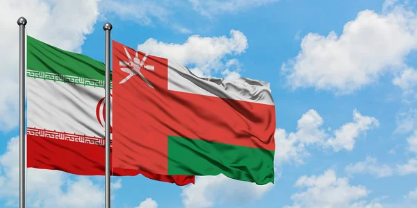 Iran and Oman flag waving in the wind against white cloudy blue sky together. Diplomacy concept, international relations. — Stock Photo, Image
