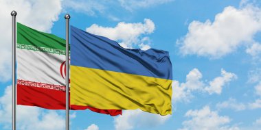 İran ve Ukrayna bayrağı birlikte beyaz bulutlu mavi gökyüzüne karşı rüzgarsal sallayarak. Diplomasi kavramı, uluslararası ilişkiler.