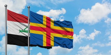 Irak ve Aland Adaları bayrağı birlikte beyaz bulutlu mavi gökyüzüne karşı rüzgarsal sallayarak. Diplomasi kavramı, uluslararası ilişkiler.