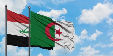 Irak ve Cezayir bayrağı birlikte beyaz bulutlu mavi gökyüzüne karşı rüzgarda sallayarak. Diplomasi kavramı, uluslararası ilişkiler.